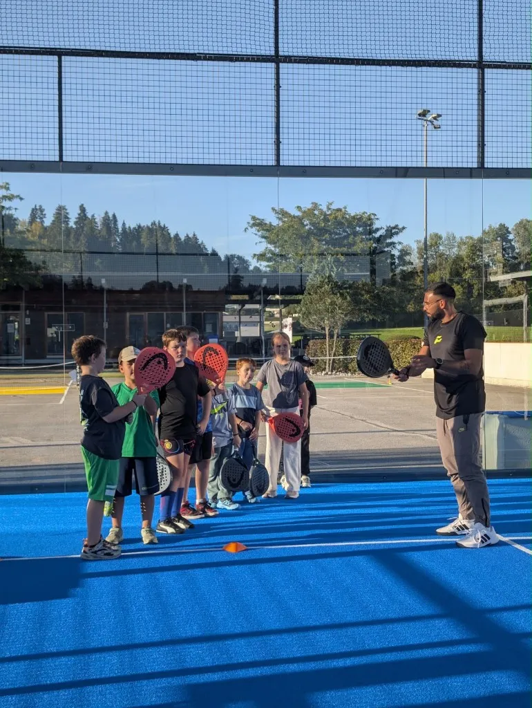 Trainer erklärt Kindern die Schlägerhaltung beim Padel